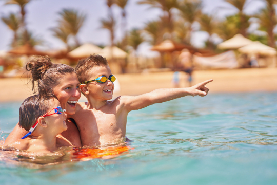 Frau mit zwei Kindern im Meer